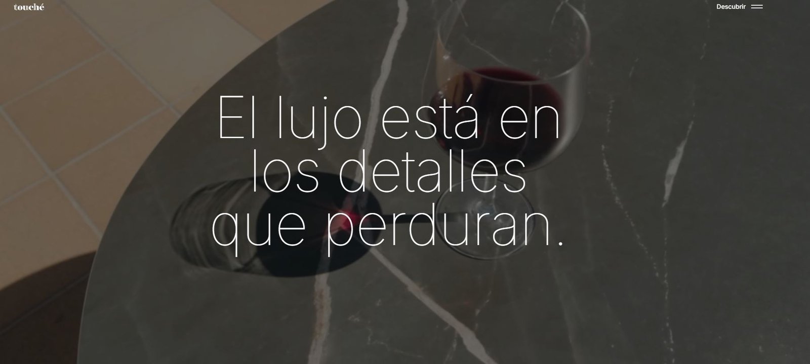 Captura de archivo de la cabecera de Touché Design, con mesa y presentación de marca